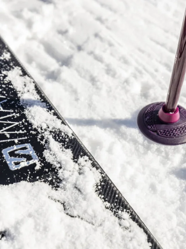 Close-up of a ski and a stick stuck in the fresh snow at Le Grand-Bornand, a symbol of winter sports and sliding in the mountains.