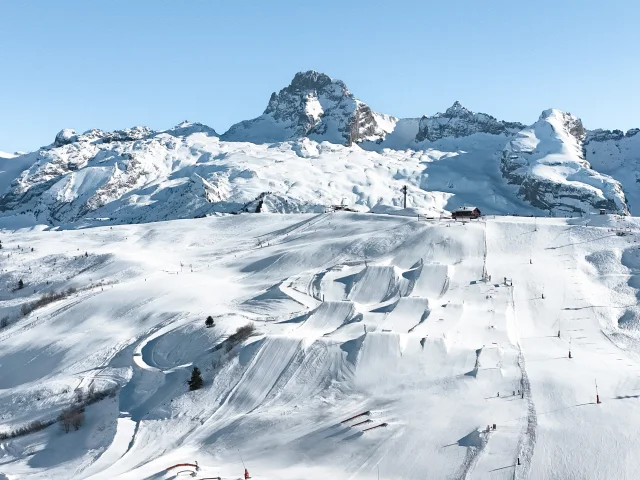 An aerial view of the Grand Bornand snowpark and its 6 hectares of freestyle facilities, with the Pointe Percée in the background.