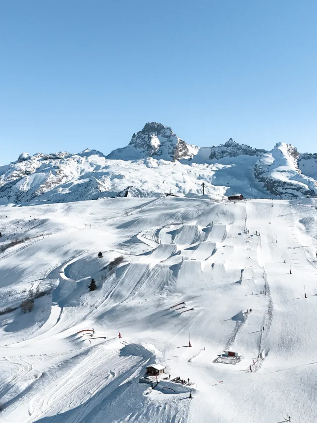 An aerial view of the Grand Bornand snowpark and its 6 hectares of freestyle facilities, with the Pointe Percée in the background.