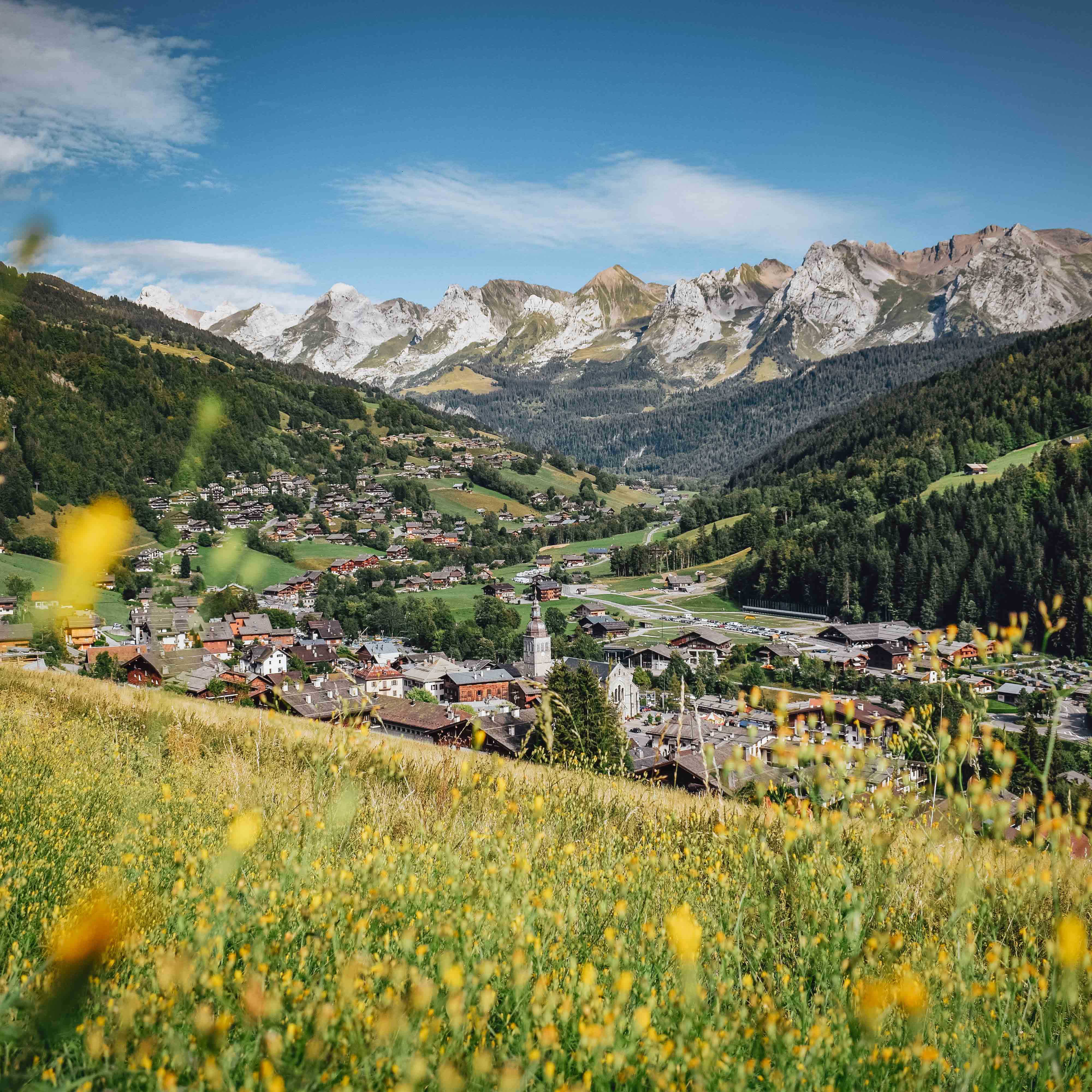 Le village du Grand-Bornand en été avec en toile de fond la chaîne des Aravis - © C. Chabod