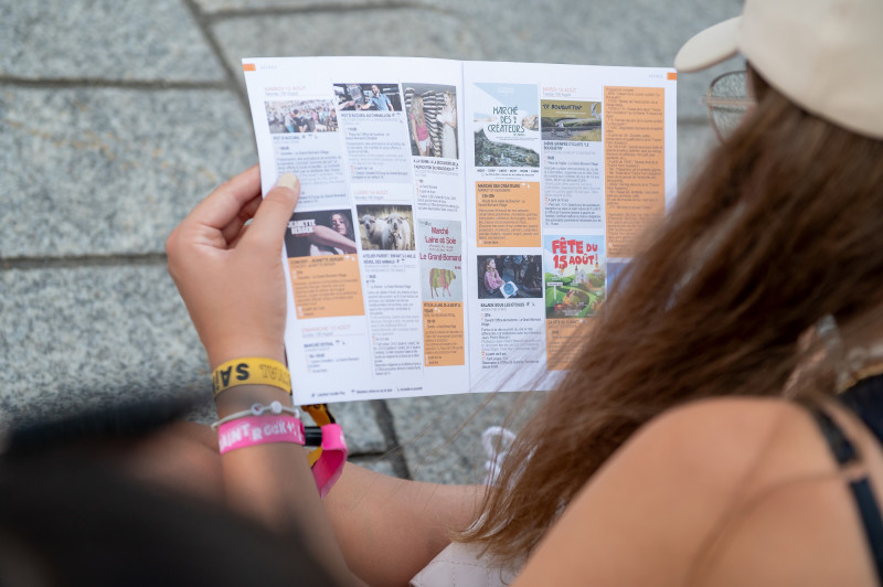 visiteuse du Grand-Bornand lisant le programme des animations d'été au pot d'accueil